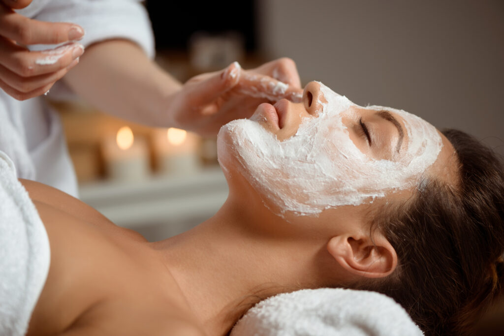 Young beautiful girl in mask for face relaxing in spa salon.